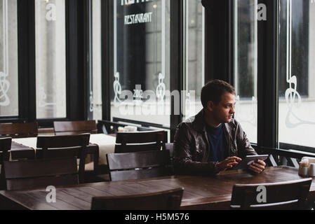 Young man or student using tablet computer in cafe Stock Photo