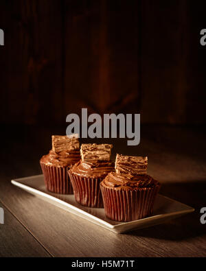 Three chocolate cakes decorated with flakes - focus on front cake Stock Photo