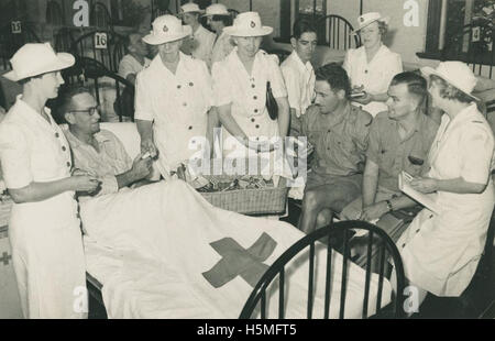 Red Cross volunteers handing out cigarette packets to patients, ca Stock Photo
