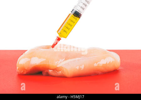 Syringe with liquid being injected to a piece of meat. Conceptual illustration for Hormones and antibiotics in food production. Stock Photo