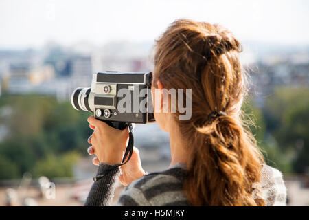 Young woman filming with vintage motion camera Stock Photo - Alamy