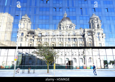 The Port of Liverpool building reflected in the glass outer wall of the Equator building across the road in Liverpool, UK Stock Photo