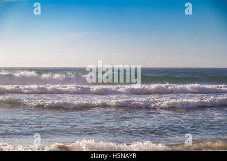 Unidentified surfer glides through the tube-wave on Adraga beach (Praia da Adraga) in Portugal Stock Photo