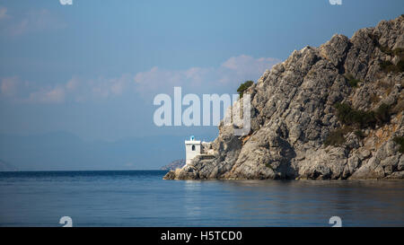 Lighthouse on a cliff in the Aegean sea. Stock Photo