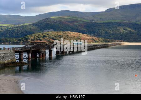 Cambrian Coast Railway train crossing Barmouth Bridge Mawddach river estuary Gwynedd Wales Stock Photo