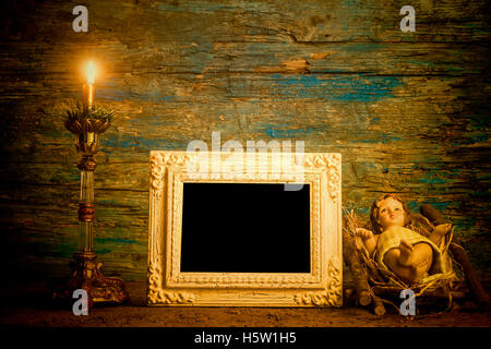 Christmas photo frame card, Baby Jesus and lit candle with empty vintage photo frame for write text or put photo Stock Photo
