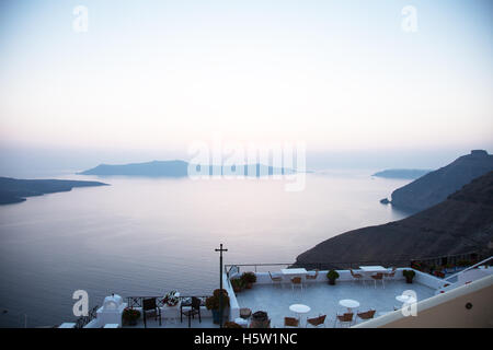 A view over the sea and some islands and a cross on a patio in the sunset Stock Photo
