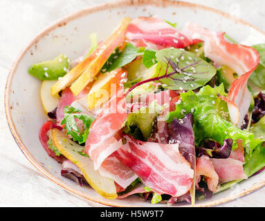 Fresh salad with bacon and pear. Selective focus Stock Photo