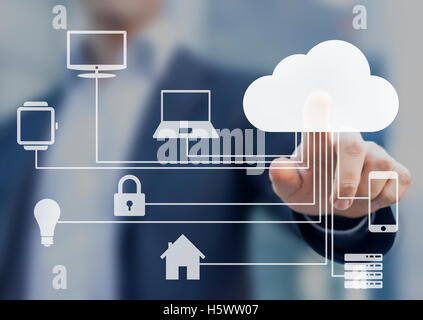 Businessman touching a cloud connected to many objects on a virtual screen, concept about internet of things Stock Photo