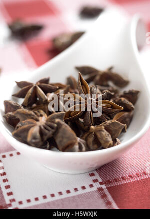 Star anise on white and red tablecloth. Selective focus Stock Photo