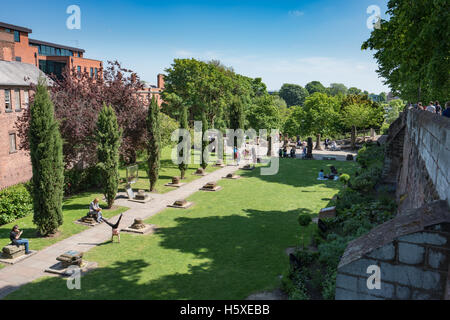 People relaxing and playing in the Chester Roman Gardens.  The garden has Roman remains and border the Chester Walls Stock Photo