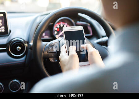 man using phone while driving the car (selective focus) - transportation and vehicle concept Stock Photo