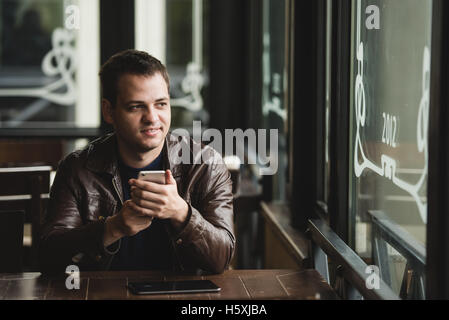 Man using a smartphone in the cafe Stock Photo