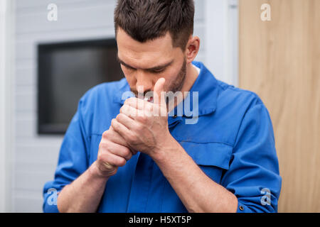 auto mechanic smoking cigarette at car workshop Stock Photo