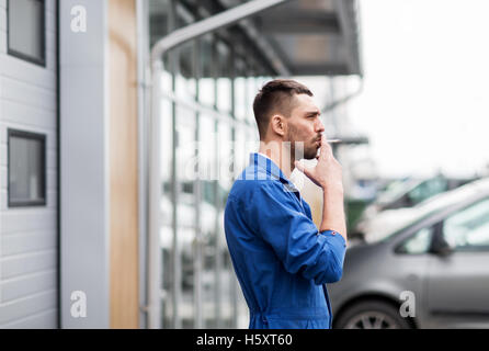 auto mechanic smoking cigarette at car workshop Stock Photo