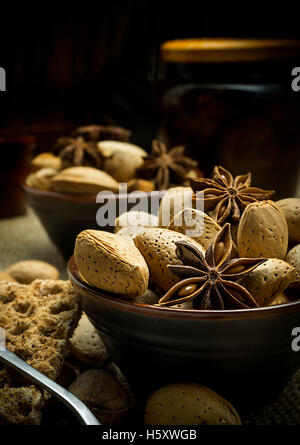 Autumn composition of almonds on a dark rustic background with star anise and apricot jam Stock Photo