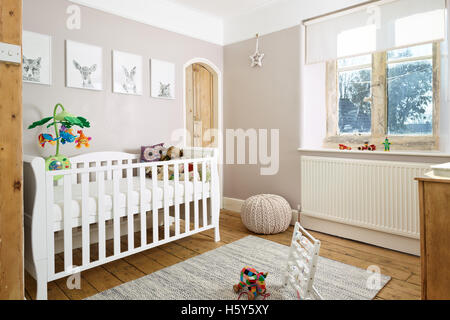 A cot bed in a traditional child's nursery in a modernised British Victorian home Stock Photo