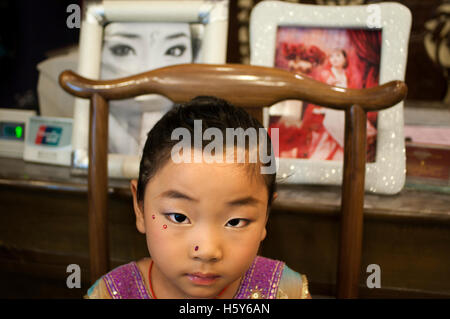 Muslim quarter of Xian, Shaanxi, China, Asia. Silk road, Huimin Street, Beiyuanmen Moslem market. A girl makeup inside a photo s Stock Photo