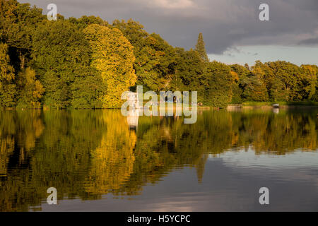 Shearwater Lake, Wiltshire, UK. 21st Oct, 2016. Shearwater, Longleat Estate. A glorious end to the day on this popular fishing and boating lake saw the setting sun illuminate the bank of trees surrounding the waterside. The Autumn is now in full swing as the deciduous trees reveal the deep hues of orange, red and yellows in the foliage. Credit:  Wayne Farrell/Alamy Live News Stock Photo