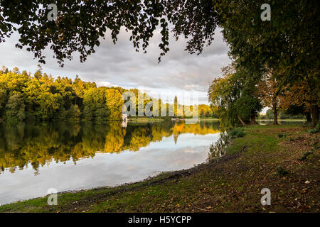 Shearwater Lake, Wiltshire, UK. 21st Oct, 2016. Shearwater, Longleat Estate. A glorious end to the day on this popular fishing and boating lake saw the setting sun illuminate the bank of trees surrounding the waterside. The Autumn is now in full swing as the deciduous trees reveal the deep hues of orange, red and yellows in the foliage. Credit:  Wayne Farrell/Alamy Live News Stock Photo