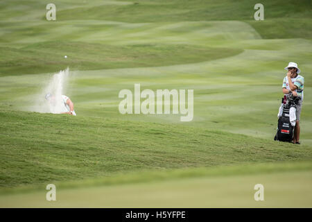 Kuala Lumpur, Malaysia. 22nd Oct, 2016. Ryan Moore hitting a shot out from the bunker, watch by his caddy. Credit:  Danny Chan/Alamy Live News Stock Photo