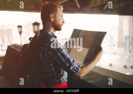 Tourist backpacker using map to travel to destinations Stock Photo