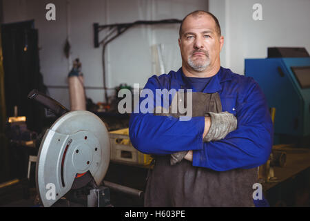 Welder standing with arm crossed in workshop Stock Photo
