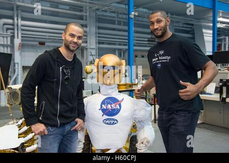 French professional basketball players Tony Parker (left) and Boris Diaw of the San Antonio Spurs pose with the NASA Valkyrie R5 Robot at the Johnson Space Center Dexterous Robotics Laboratory during a tour led by French astronaut Thomas Pesquet of the European Space Agency April 2, 2015 in Houston, Texas. Stock Photo
