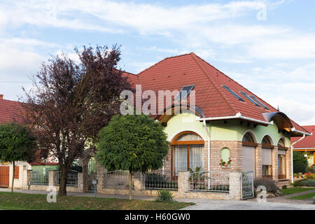 Detached house. Well-kept. Beautiful house. Detached house with ornamental trees and flowers around. Stock Photo
