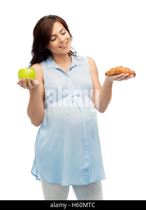 happy pregnant woman with apple and croissant Stock Photo