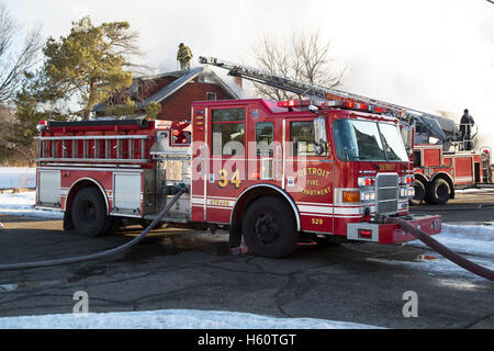 Aerial truck, Engine company, and firefighters extinguishing house fire, Detroit, Michigan USA Stock Photo