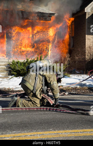 Firefighter preparing hoses, house fire, Detroit, Michigan USA Stock Photo