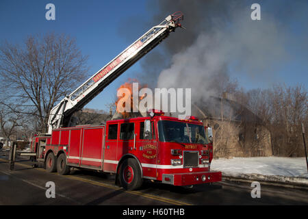 Aerial truck and firefighters extinguishing house fire, Detroit, Michigan USA Stock Photo