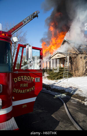 Aerial truck and firefighters extinguishing house fire, Detroit, Michigan USA Stock Photo