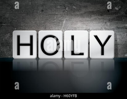 The word 'Holy' written in white tiles against a dark vintage grunge background. Stock Photo