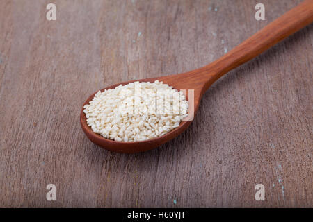 white sesame seeds in wooden spoon on wood background Stock Photo