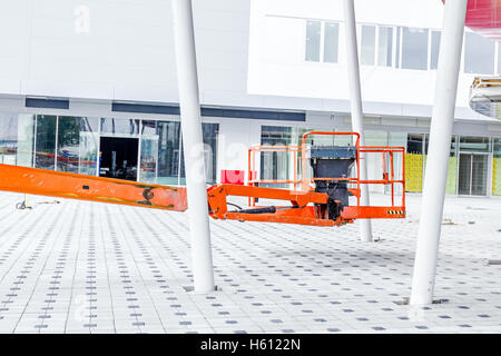 High elevated cherry picker people are working at new assembled canopies on construction site. Stock Photo