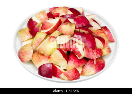 Fresh autumn apples are cut on small pieces. Fruit are made for production of apple juice in house conditions. Isolated with pat Stock Photo