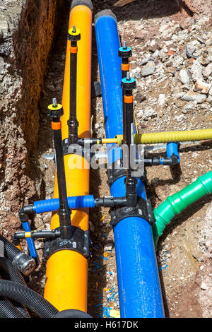 Earthworks, construction site, laying of new supply lines, yellow natural gas pipeline, blue drinking water, Stock Photo