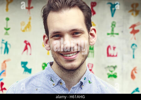 Portrait of a happy young man standing against a colourful funky background Stock Photo