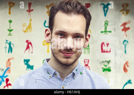 Portrait of a friendly young man in front of a colourful funky background Stock Photo