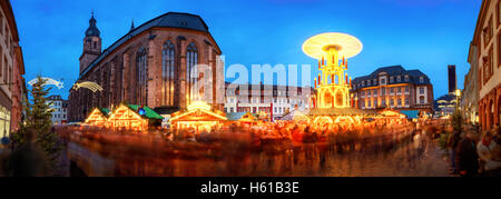 Christmas market in Heidelberg, Germany, a panorama shot at dusk showing illuminated kiosks, historic architecture and blurred p Stock Photo