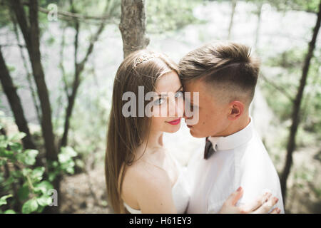 Wedding couple man, bride kissing and hugging on a background of the river, mountains. Beauty portrait Stock Photo