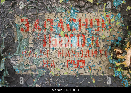 Old cracked paint words "emergency exit, key is on" Stock Photo