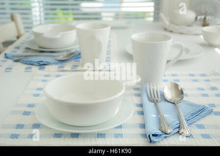 Blue and white create a simple elegant table setting.  Extremely shallow depth of field.  Shot in natural light. Stock Photo