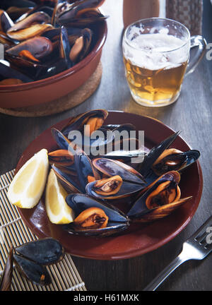 Fresh mussels steamed with beer on a wooden background Stock Photo