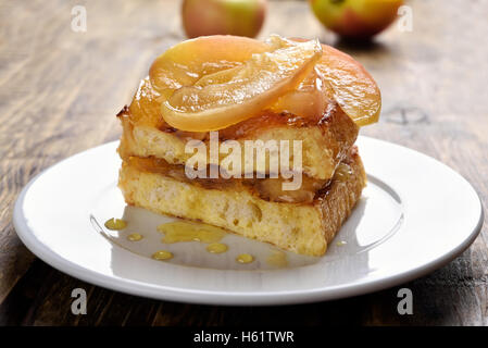 French toast stuffed with caramelized apples on white plate Stock Photo