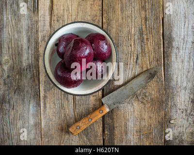 boiled beets in enameled metal bowl on an old weathered wooden table Stock Photo