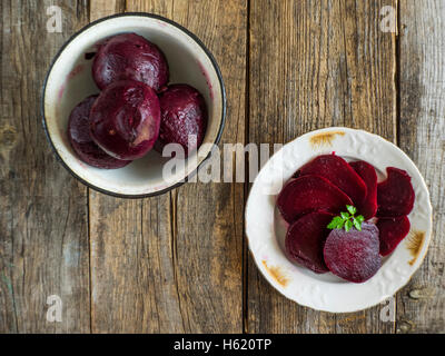 boiled beets in enameled metal bowl on an old weathered wooden table Stock Photo