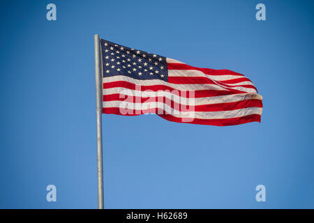 American flag against blue sky. Vignette. Stock Photo